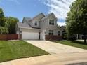 Charming two-story home features a well-manicured lawn, brick accents, light gray siding, and a classic white two car garage door at 8010 Raspberry Dr, Frederick, CO 80504