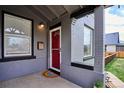 Close-up of the covered front porch featuring gray brick, red door, and mailbox at 3130 N Race St, Denver, CO 80205