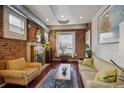 Cozy living room with exposed brick, hardwood floors, and lots of natural light at 3130 N Race St, Denver, CO 80205