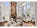 Spacious living room with a stone fireplace and large windows at 6017 Merchant Pl, Parker, CO 80134