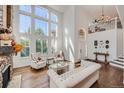 Bright living room with hardwood floors, high ceilings, and a fireplace at 6017 Merchant Pl, Parker, CO 80134