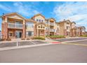 Apartment complex exterior featuring balconies, tidy landscaping, and designated parking spaces at 5765 N Genoa Way # 1-103, Aurora, CO 80019