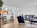 Bright living area featuring an open layout, sleek hard floors, modern furniture, and kitchen view at 5765 N Genoa Way # 1-103, Aurora, CO 80019