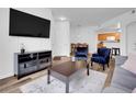Open living area with modern furniture, a large TV, and easy access to dining and kitchen at 5765 N Genoa Way # 1-103, Aurora, CO 80019