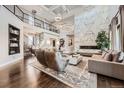 Spacious living room with a soaring ceiling, striking marble fireplace, and abundant natural light at 8017 S Valleyhead Way, Aurora, CO 80016