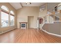 Spacious living room features vaulted ceilings, hardwood floors, a fireplace, and large arched windows for abundant natural light at 1445 Colebrook Ct, Castle Rock, CO 80109