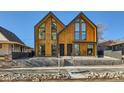 Modern home featuring a unique twin gable design, wooden siding, and a welcoming front porch at 3829 Osage St, Denver, CO 80211