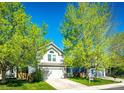 Inviting two-story home with an attached garage, lush lawn, and vibrant trees under a clear sky at 11335 Haswell Dr, Parker, CO 80134
