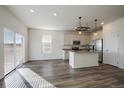 Open concept kitchen with white cabinets, stainless steel appliances, and center island at 1110 Black Saddle St, Elizabeth, CO 80107