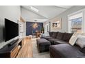 Open living space with vaulted ceilings, modern lighting, and sleek media center for comfortable living at 6240 W 24Th Ave, Edgewater, CO 80214