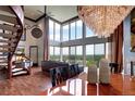 Expansive living room with spiral staircase, chandelier, floor-to-ceiling windows, and dining area at 1900 E Girard Pl # 901, Englewood, CO 80113