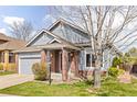 Well-maintained home with brick and siding exterior, featuring a neatly landscaped lawn and mature tree at 2590 S Independence St, Lakewood, CO 80227