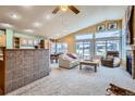 Bright living room boasts vaulted ceilings, fireplace, bar seating and a seamless flow to the outdoor space at 32 Canongate Ln, Highlands Ranch, CO 80130