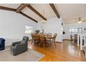 Open dining area with wood floors, exposed beams, and ample space for a large table, adjacent to the kitchen at 3907 E 133Rd Ct, Thornton, CO 80241
