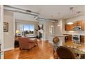 Open-concept living room featuring a fireplace, hardwood floors, and a balcony with neighborhood views at 10111 Inverness Main St # 312, Englewood, CO 80112