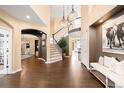 Inviting foyer with hardwood floors, a grand staircase, designer lighting, and stylish decor at 8390 Coyote Dr, Castle Pines, CO 80108