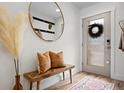Inviting entryway with a decorative mirror, wooden bench, and stylish decor at 9300 E Florida Ave # 1202, Denver, CO 80247