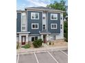 Modern townhouse showcasing a blue and gray exterior, red doors, and well-maintained landscaping at 9300 E Florida Ave # 1202, Denver, CO 80247