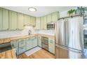 Modern kitchen with stainless steel appliances, sage cabinets, and butcher block countertops at 3080 N Cook St, Denver, CO 80205