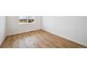Well-lit bedroom featuring hardwood floors and a bright window at 45927 Wood Thrush Ave, Bennett, CO 80102