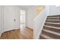 Bright entryway with wood floors and staircase leading to the second floor at 45927 Wood Thrush Ave, Bennett, CO 80102
