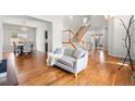 Open-concept living space with hardwood floors, staircase, and adjacent dining area at 5604 S Shawnee St, Aurora, CO 80015