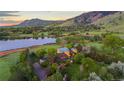 Picturesque aerial shot showcases a charming estate, set against a serene lake and lush greenery at 700 Utica Ave, Boulder, CO 80304