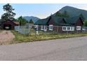 Street view of home and detached garage, with a well-maintained yard and fencing at 245 Lower Glenway St, Palmer Lake, CO 80133