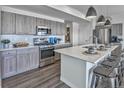 Kitchen with stainless steel appliances, wooden cabinets, subway tile backsplash, and an island with bar seating at 834 N Bently St, Watkins, CO 80137