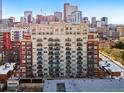 Multi-story building with cream and red brick exterior and multiple decks offers urban living at 1950 N Logan St # 1109, Denver, CO 80203