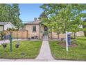 A charming brick home is showcased with a well-manicured lawn and a neatly paved walkway at 5704 Ammons St, Arvada, CO 80002