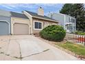 Attractive townhome showcasing a stone facade, attached garage, driveway, and mature landscaping at 19616 E Milan Cir, Aurora, CO 80013