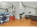 Bright living room with a stone fireplace, vaulted ceiling, hardwood floors, and staircase at 19616 E Milan Cir, Aurora, CO 80013