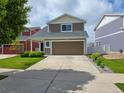 A well-maintained two-story home featuring a front lawn and a two-car garage at 20768 Randolph Pl, Denver, CO 80249