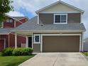 A well-maintained two-story home featuring a front lawn and a two-car garage at 20768 Randolph Pl, Denver, CO 80249