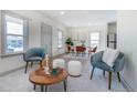 Inviting living space with modern furnishings, including accent chairs, ottomans, and a view into the dining area at 4325 S Cherokee St, Englewood, CO 80110