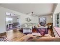 Bright living room with hardwood floors, a cozy seating arrangement, and natural lighting at 6451 Crestbrook Dr, Morrison, CO 80465
