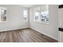 Inviting bedroom with hardwood floors, light walls, and bright windows at 5549 Riverbend Ave, Firestone, CO 80504