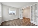 Bright living room with hardwood floors and elegant glass paneled french doors at 5549 Riverbend Ave, Firestone, CO 80504