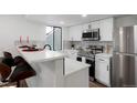 Modern kitchen featuring stainless steel appliances, white cabinetry and a breakfast bar with seating at 8701 Huron St # 2-106, Thornton, CO 80260