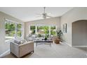 Bright living room with large windows, neutral tones, and comfortable seating arrangement at 3570 E Arapahoe Pl, Centennial, CO 80122