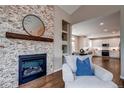 Living room featuring a stone fireplace and cozy armchair with blue pillow at 5597 S Buchanan St, Aurora, CO 80016