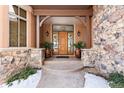 Inviting entryway with double doors, stone accents, and potted plants at 9977 Elkhorn St, Littleton, CO 80127