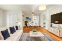 Bright living room with an open floorplan, hardwood floors, couch, and modern decor at 3075 N Elm Ave, Denver, CO 80207