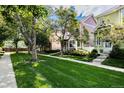Street view of well-kept townhomes with vibrant colors, lush lawns, sidewalks, and tree-lined street at 1655 S Buckley Cir, Aurora, CO 80017