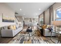 Open concept living room showcasing hardwood floors, stylish rug, and natural light from large windows at 10659 Montecito Dr, Lone Tree, CO 80124