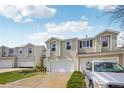 Two-story home with white siding, attached garages, and manicured lawn at 21961 E Crestline Pl, Aurora, CO 80015