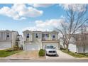 Two-story home with white siding, attached garages, and manicured lawn at 21961 E Crestline Pl, Aurora, CO 80015