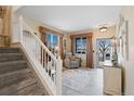 Bright foyer featuring tile flooring, neutral colors, window views, lots of light, and stairs to the upper level at 10041 Dillon Cir, Commerce City, CO 80022