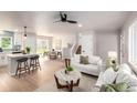 Inviting living area flowing into the kitchen, featuring hardwood floors, neutral tones, and modern decor at 1011 Yeager Dr, Longmont, CO 80501